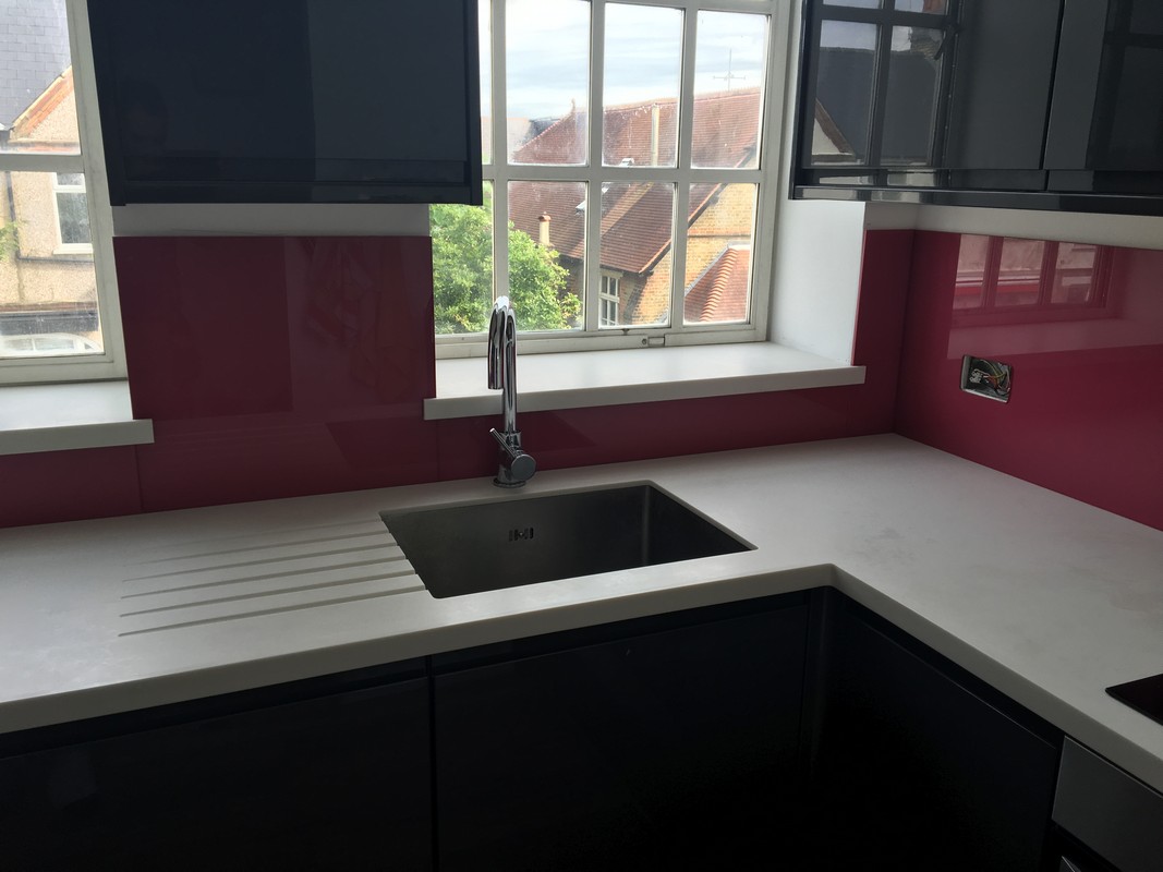 Deep plum coloured glass splashback in modern Dalston kitchen